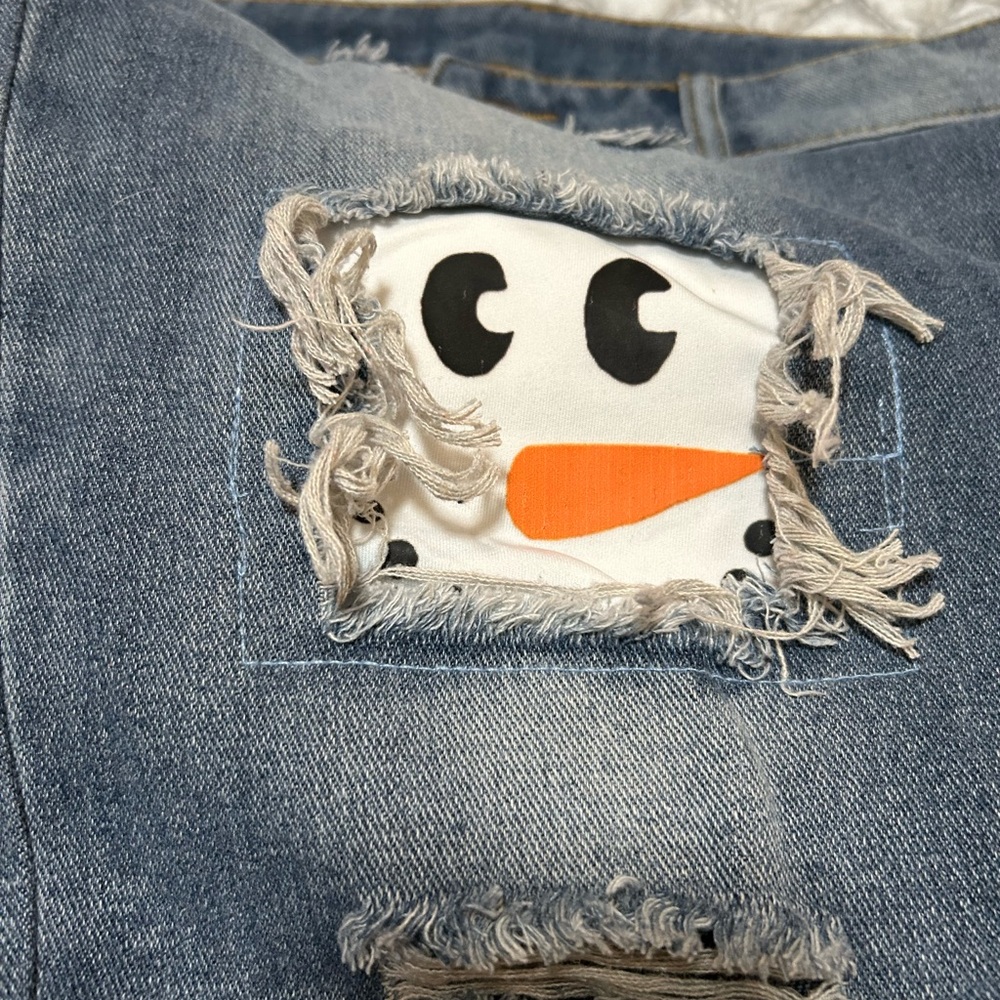 Snowman patch distressed jeans in light blue with faded seat 29” inseam